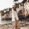 The White Linen Shirt -Modern Ladies Wear Store mikuta white linen shirt white linen shorts relaxed raffia bag natural raffia bucket hat black studded leather sandals model aina 0770